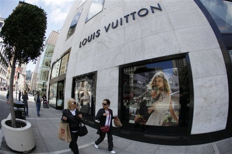 Two women walk past the Louis Vuitton store June 3 at Union Square in San Francisco. Retail sales plunged in May by the largest amount in eight months, raising new worries about the durability of the economic recovery.